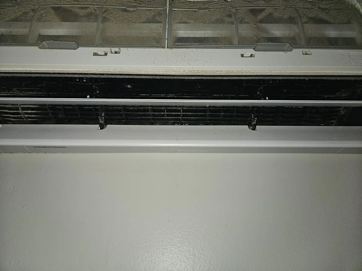 Blower wheel and vane cage of a Fujitsu head in Cumberland, RI caked with grey buildup before cleaning