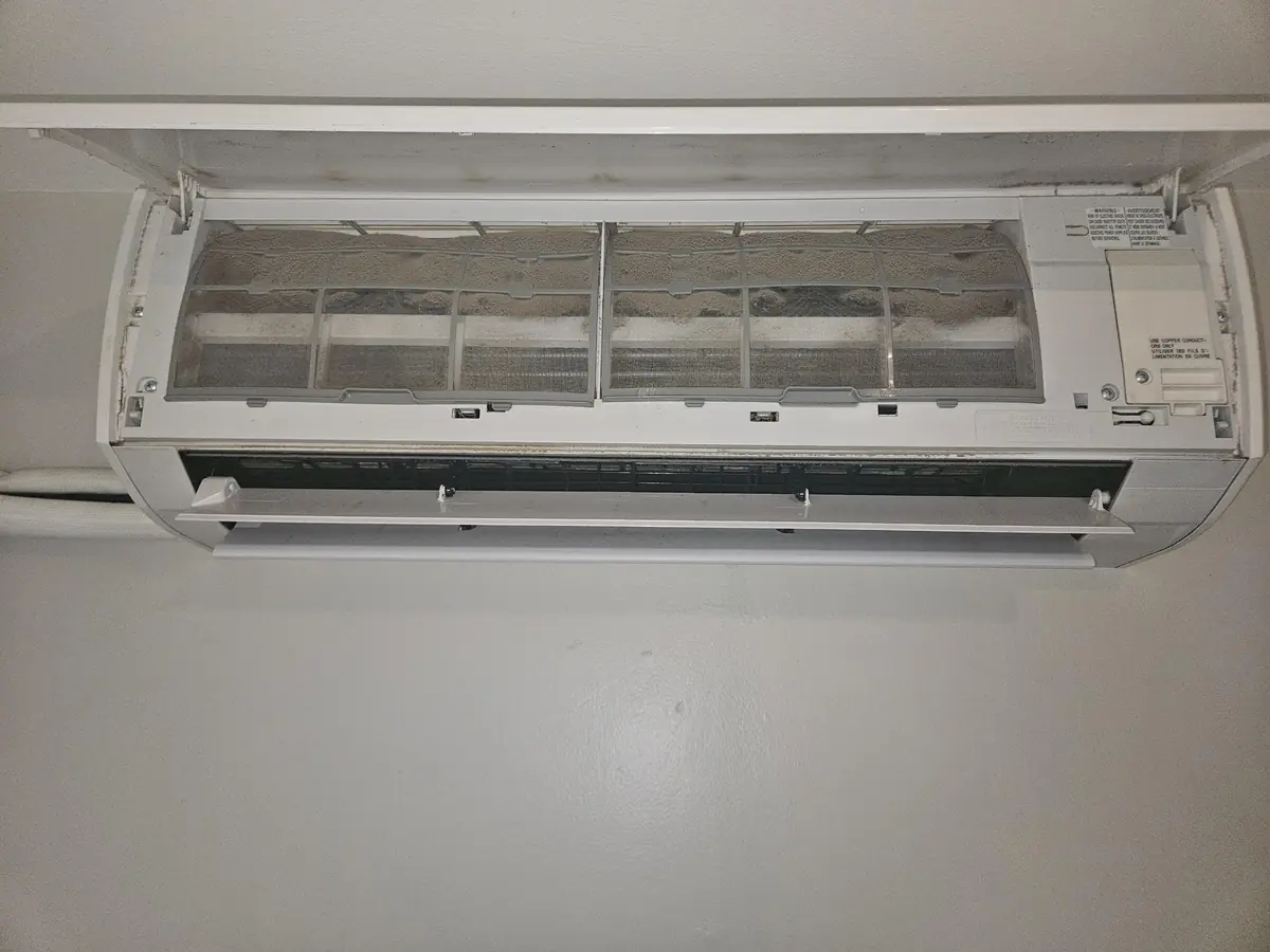 Fujitsu mini-split head opened in Cumberland, RI with filters packed grey with dust before cleaning