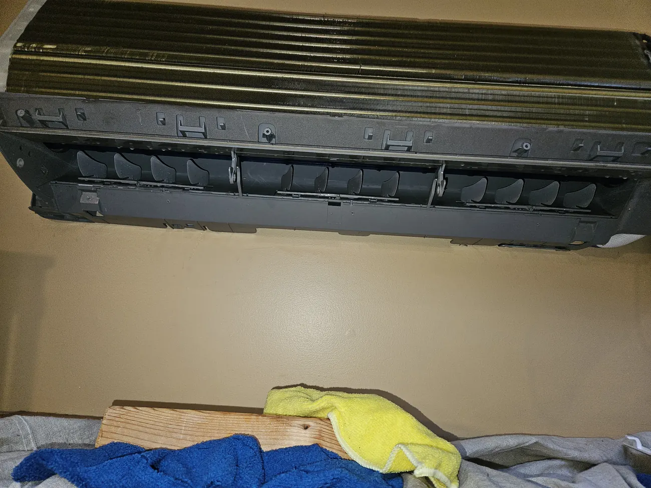 Indoor mini-split head opened up with drop cloths laid below in a Falmouth MA home