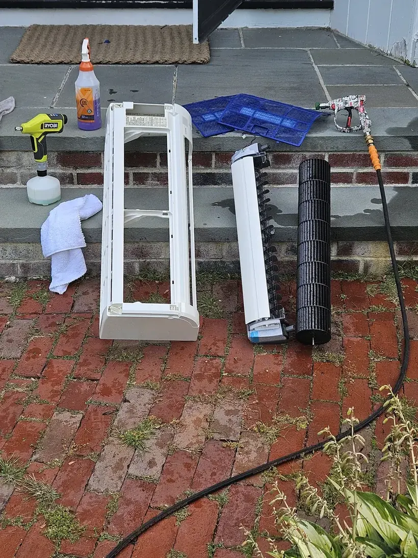 Mini-split cover, filters and blower wheel laid out for washing during a Lexington deep clean