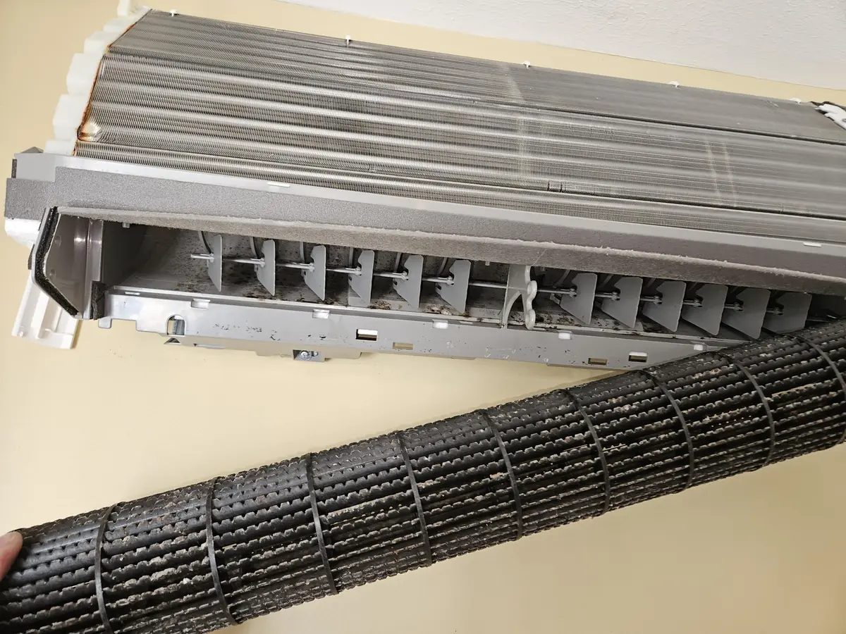 Buildup packed into the louvers and vanes of a mini-split in Pepperell, MA before cleaning